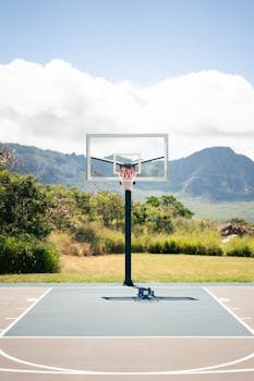 Home Outdoor basketball court with stunning mountain backdrop on a sunny day.